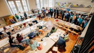 Attendees of singing workshop performing in hall. 