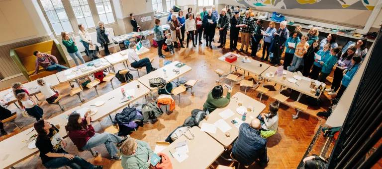 Group of people singing in community hall. 