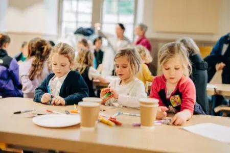 Children making crafts at a table. 